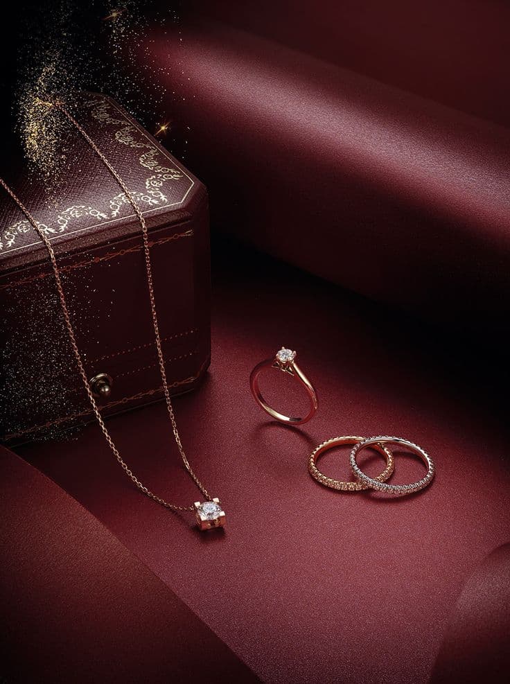 Trilogy ring with round and pear-cut diamonds on dark linen, side view